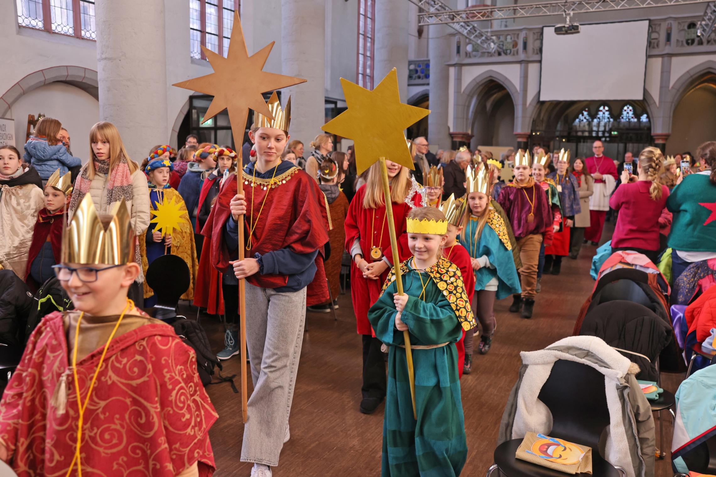 Sternsinger ziehen in die Kirche, strahlende Gesichter