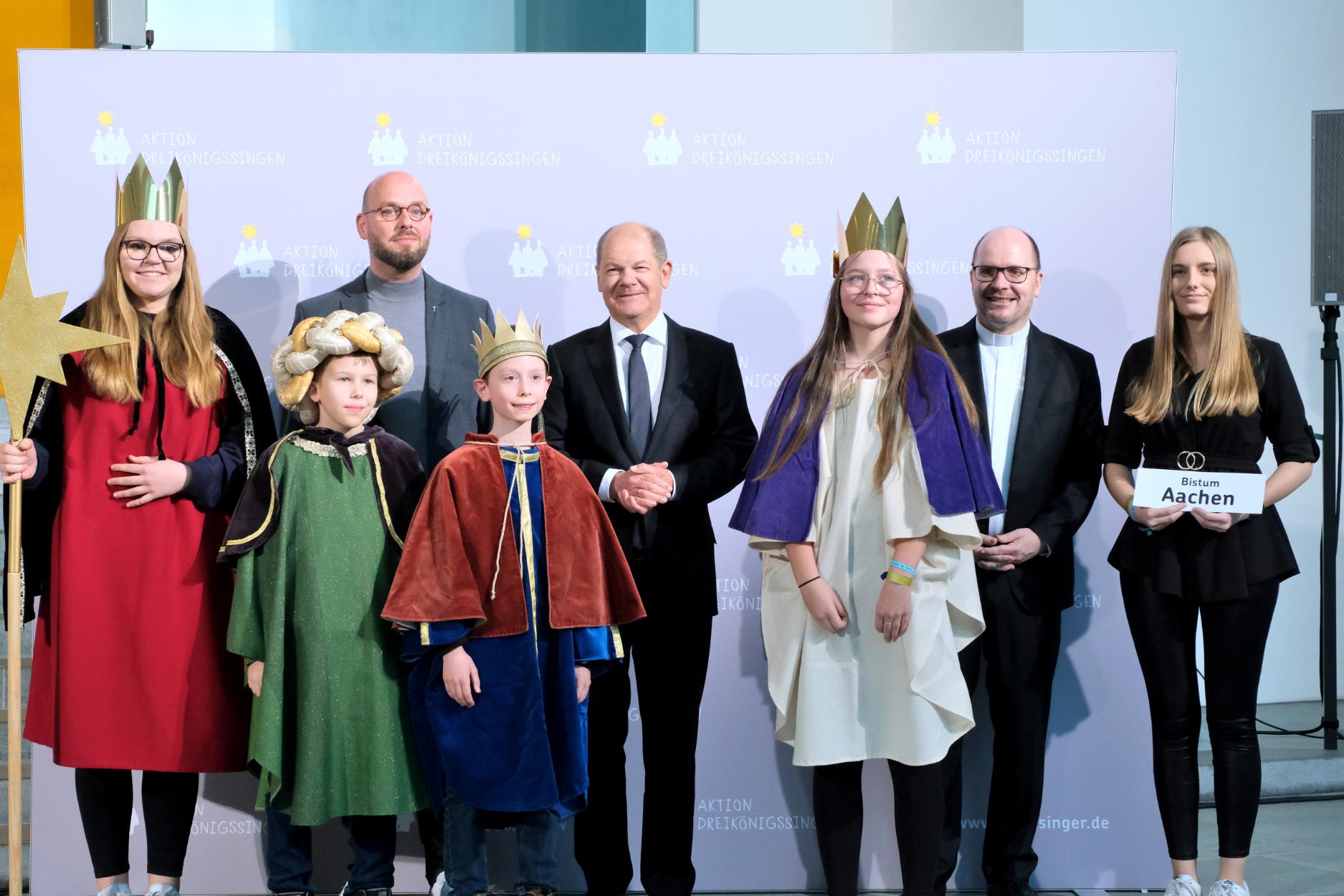 Die Sternsinger Paul (10), Philipp (10), Christin (13) und Alina (14) sowie Begleiterin Kim Bahlke aus der katholischen Kirchengemeinde St. Clemens, Kaldenkirchen, in Nettetal vertraten das Bistum Aachen am Donnerstagnachmittag beim Sternsinger-Empfang von Bundeskanzler Olaf Scholz zur 65. Aktion Dreikönigssingen. Zum Gruppenfoto mit dem Kanzler stellten sie sich gemeinsam mit Pfarrer Dirk Bingener, Präsident des Kindermissionswerks ‚Die Sternsinger‘, und Domvikar Stefan Ottersbach, Bundespräses des Bundes der Deutschen Katholischen Jugend (BDKJ), im Bundeskanzleramt auf. (c) Ralf Adloff/ Kindermissionswerk