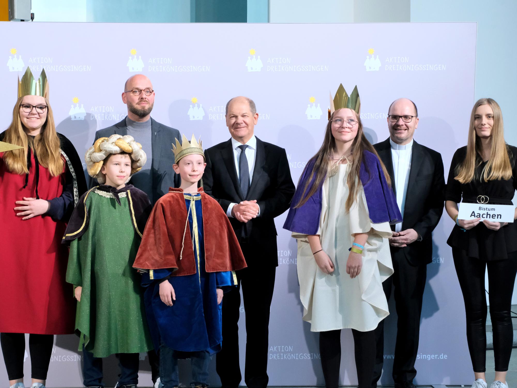 Die Sternsinger Paul (10), Philipp (10), Christin (13) und Alina (14) sowie Begleiterin Kim Bahlke aus der katholischen Kirchengemeinde St. Clemens, Kaldenkirchen, in Nettetal vertraten das Bistum Aachen am Donnerstagnachmittag beim Sternsinger-Empfang von Bundeskanzler Olaf Scholz zur 65. Aktion Dreikönigssingen. Zum Gruppenfoto mit dem Kanzler stellten sie sich gemeinsam mit Pfarrer Dirk Bingener, Präsident des Kindermissionswerks ‚Die Sternsinger‘, und Domvikar Stefan Ottersbach, Bundespräses des Bundes der Deutschen Katholischen Jugend (BDKJ), im Bundeskanzleramt auf. (c) Ralf Adloff/ Kindermissionswerk