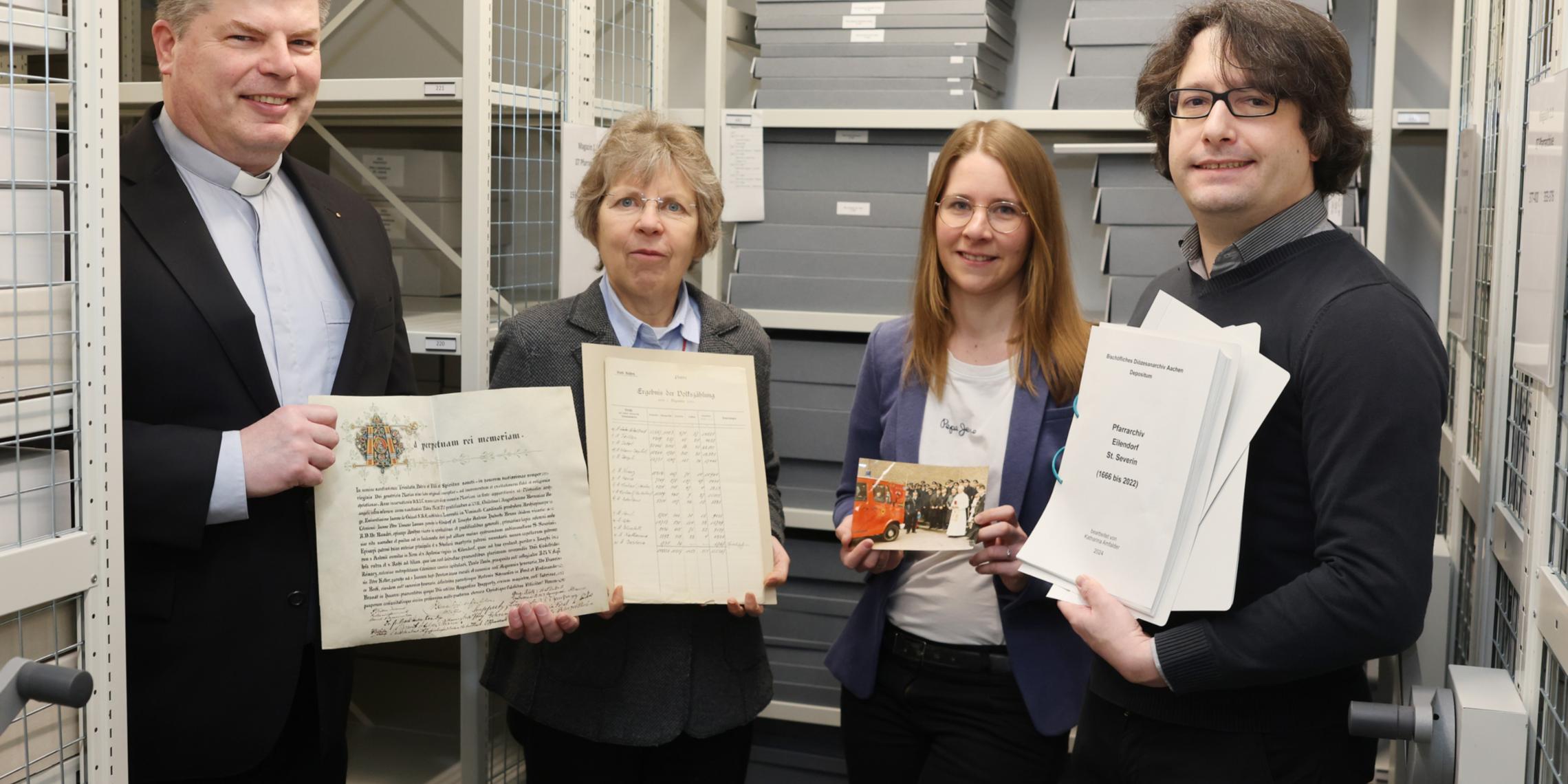 Angekommen im „Gedächtnis des Bistums Aachen“: Über die sichere Lagerung der Pfarrarchive und die Übergabe der Findbücher freuen sich (von links) der Eilendorfer Pfarrer Alexius Puls, Diözesanarchivdirektorin Dr. Beate Sophie Fleck, Referentin für Pfarrarchivpflege Katharina Amfalder sowie Juliano de Assis Mendonça, Archivberater beim Landschaftsverband Rheinland (LVR).  Foto: Bistum Aachen/Andreas Steindl