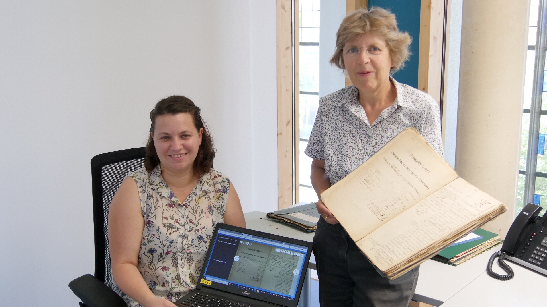 Nächster Schritt in der Digitalisierung: Archivarin Julia Haberstock (l.) und Dr. Beate Sophie Fleck (r.), Leiterin des Diözesanarchivs, freuen sich, dass die Ortsakten aus den belgischen Gebieten um Eupen, Malmedy und St. Vith ab sofort online einsehbar. (c) Bistum Aachen / Anja Klingbeil