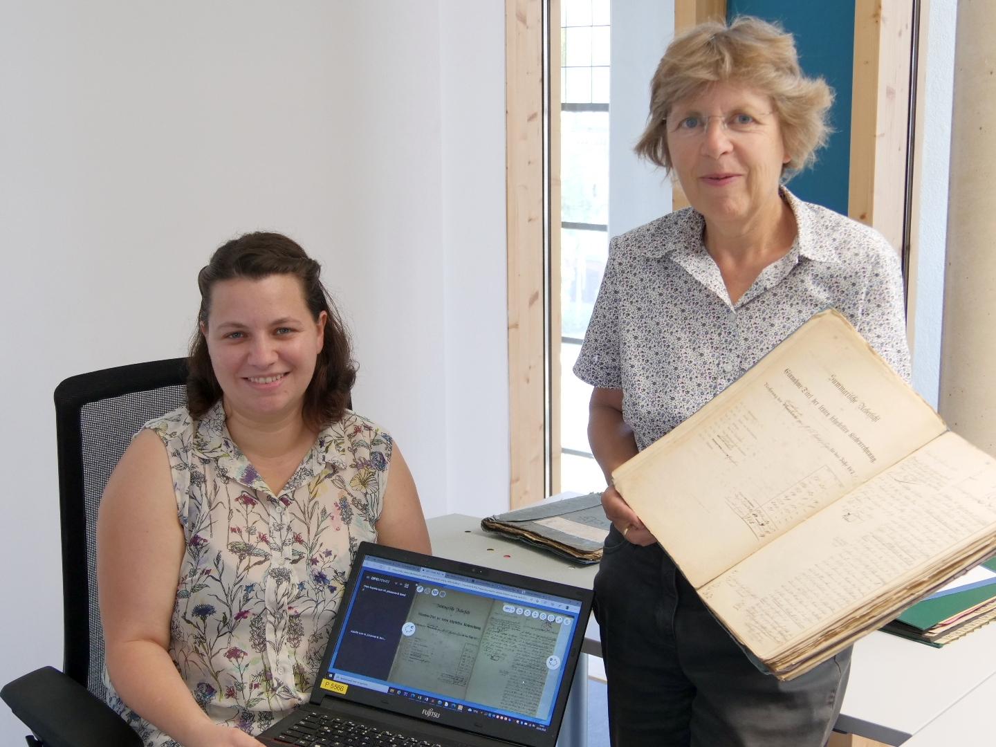 Nächster Schritt in der Digitalisierung: Archivarin Julia Haberstock (l.) und Dr. Beate Sophie Fleck (r.), Leiterin des Diözesanarchivs, freuen sich, dass die Ortsakten aus den belgischen Gebieten um Eupen, Malmedy und St. Vith ab sofort online einsehbar.