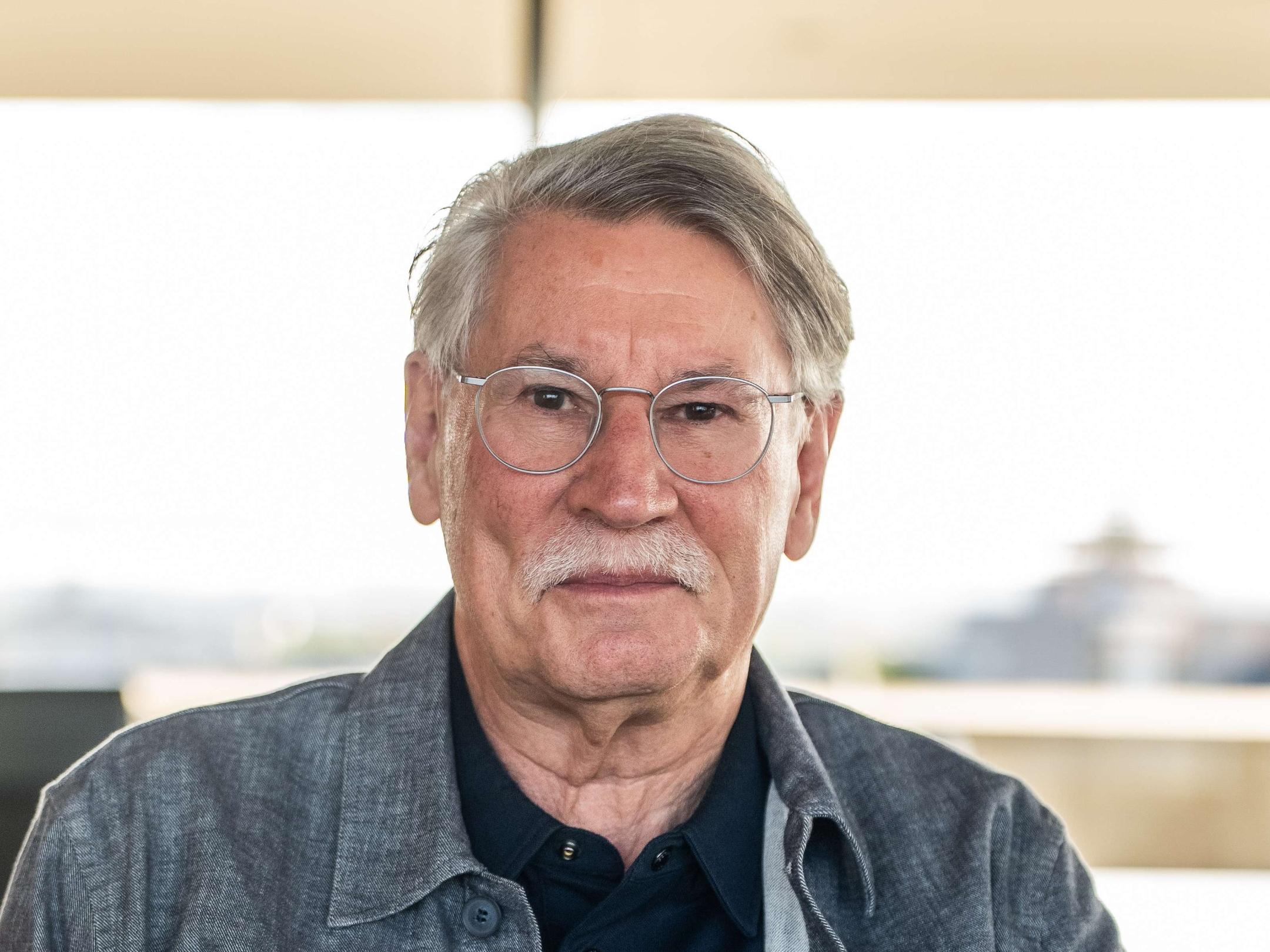 Mann mit Brille, mit weißem Oberlippenbart, Jeanshemd und schwarzem T-Shirt
