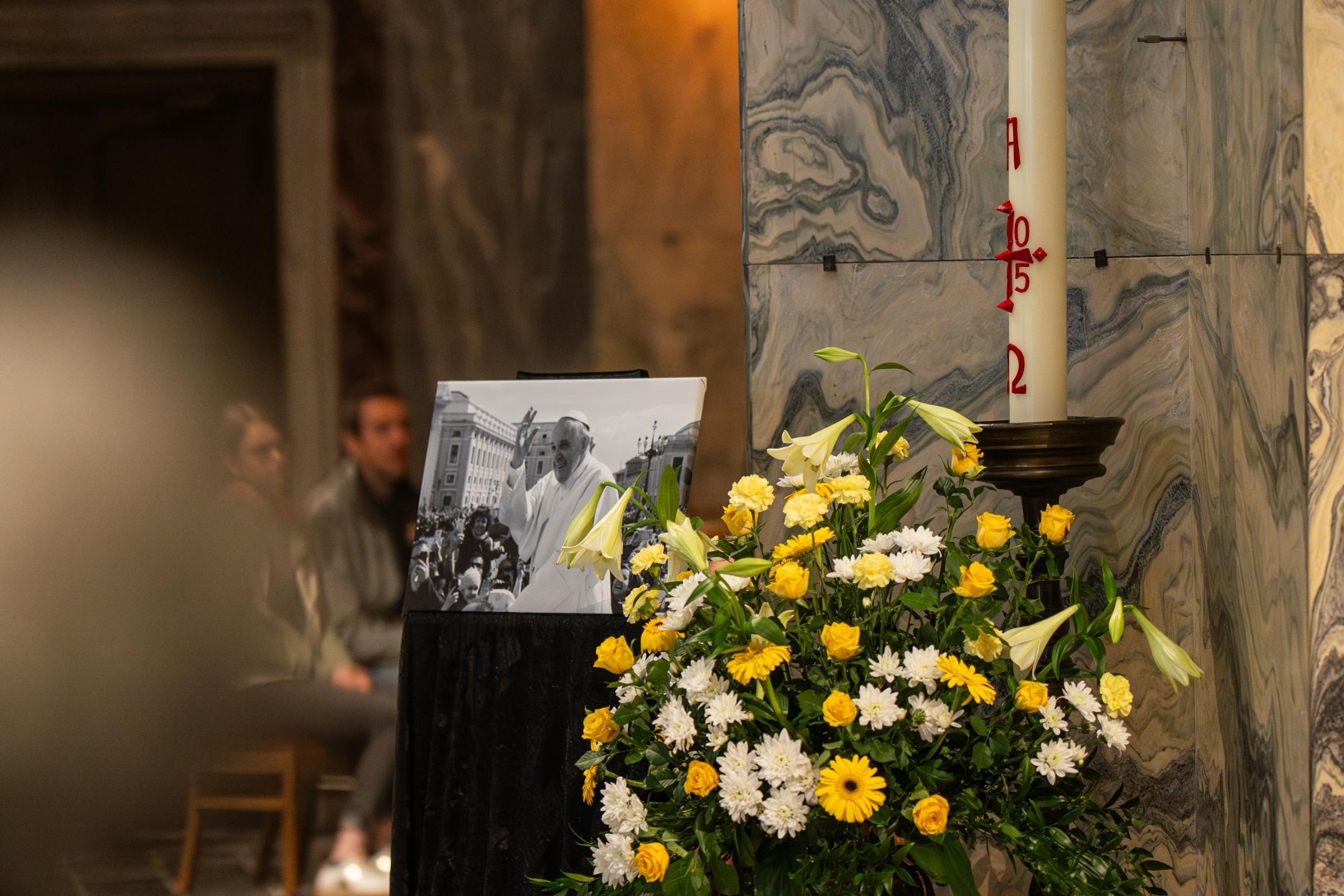 Bild von Papst Franziskus neben einer Osterkerze, vor einer Säule im Aachener Dom