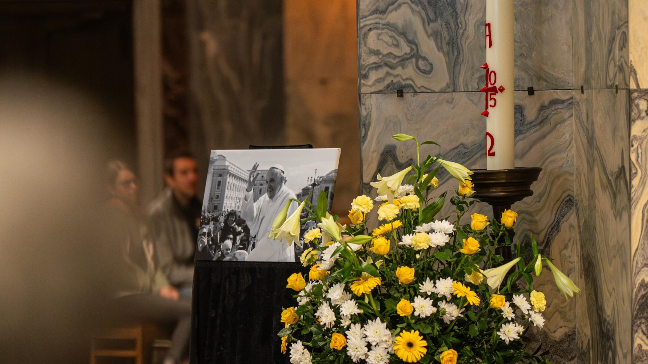 Bild von Papst Franziskus neben einer Osterkerze, vor einer Säule im Aachener Dom