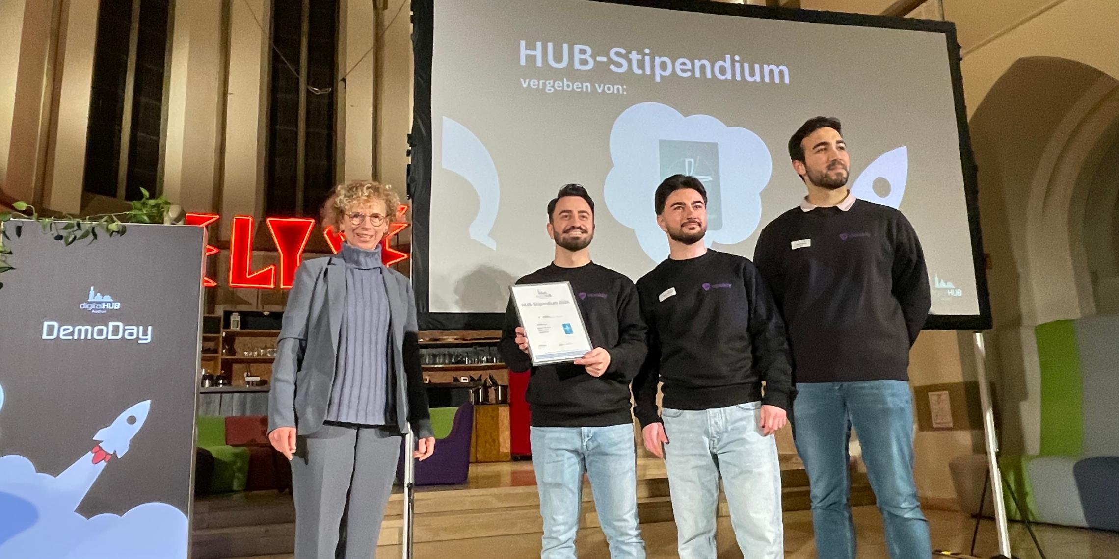 Als Partner des digitalHUB hat Dr. Angela Reinders das Stipendium des Bistums Aachen an die Startup-Gründer von apakly übergeben.