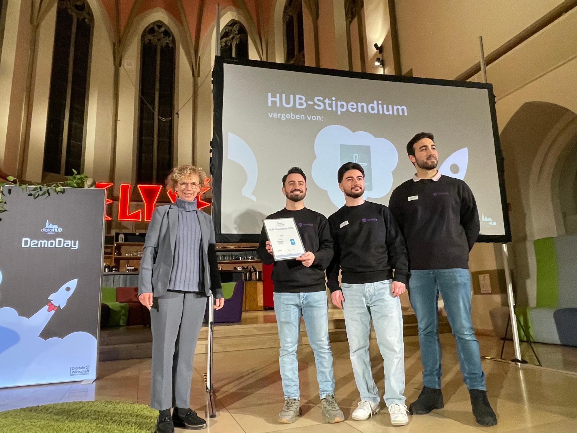 Als Partner des digitalHUB hat Dr. Angela Reinders das Stipendium des Bistums Aachen an die Startup-Gründer von apakly übergeben. (c) digitalHUB Aachen e.V.