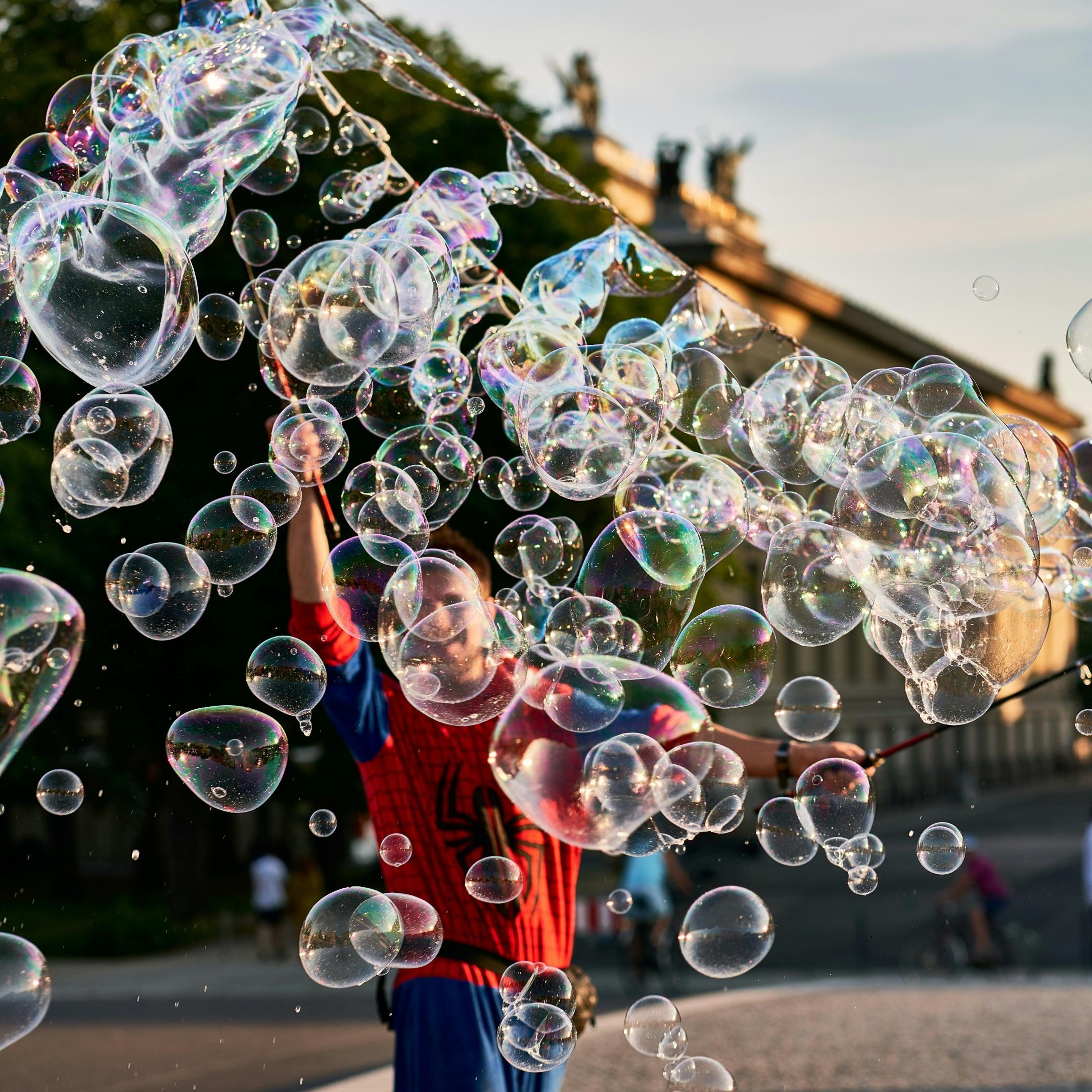 Seifenblasen, Mensch in roter Jacke (c) Unsplash/Norbert Braun Seifenblasen, Mensch in roter Jacke