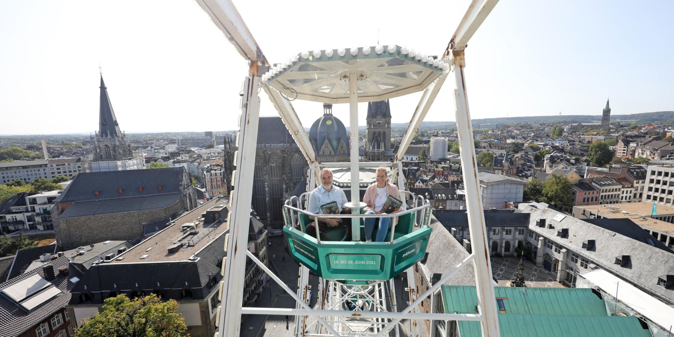 Mit der grünen Gondel zur Heiligtumfahrt Aachen geht es hoch hinaus: Am höchsten Punkt erreicht das Riesenrad 45 Meter Höhe und bietet einen großartigen Blick auf den Aachener Dom. Das ließen sich auch Dompropst und Wallfahrtsleiter Rolf-Peter Cremer sowie Projektmitarbeiterin Nadine Braun nicht entgehen.