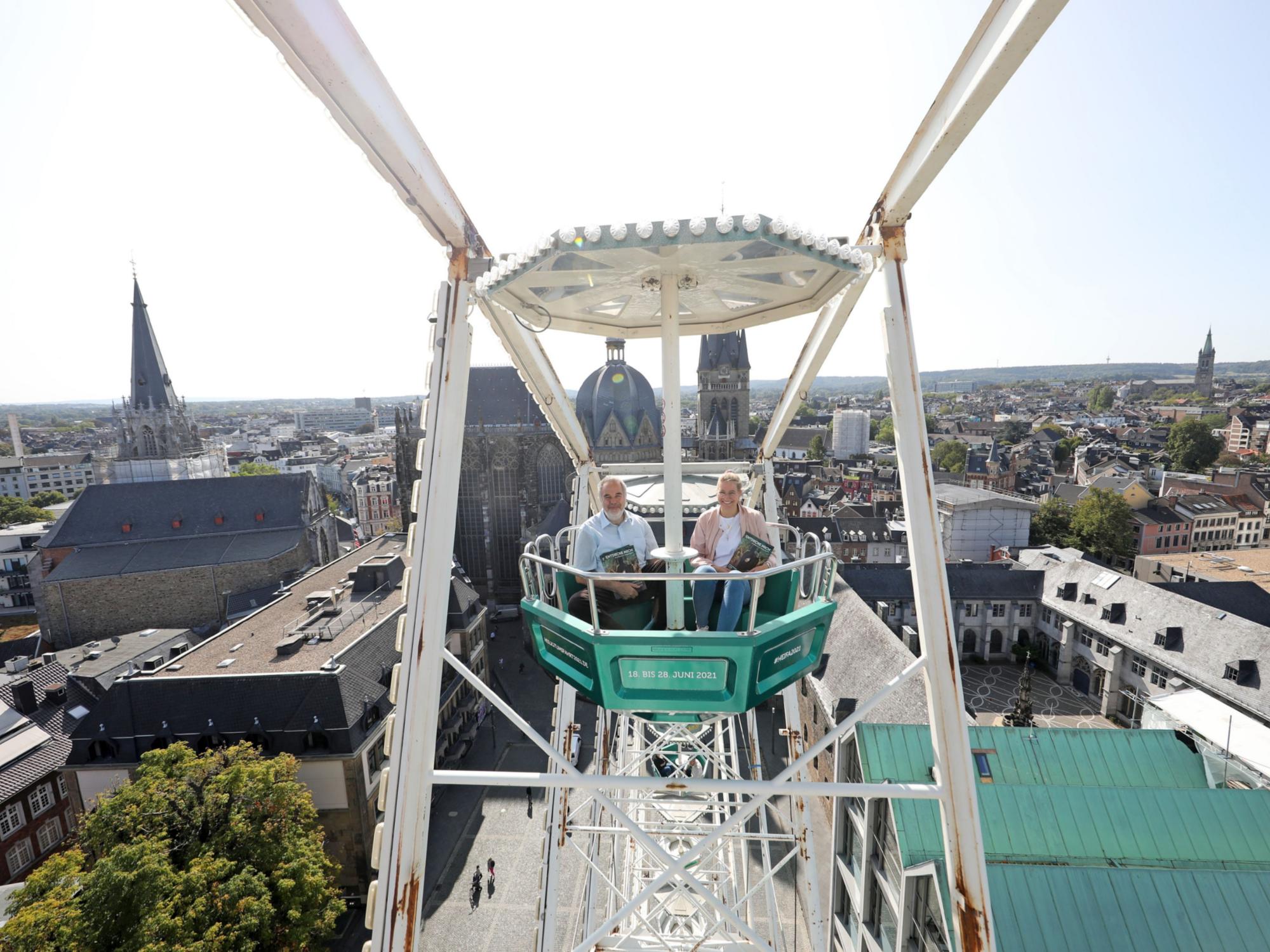 Mit der grünen Gondel zur Heiligtumfahrt Aachen geht es hoch hinaus: Am höchsten Punkt erreicht das Riesenrad 45 Meter Höhe und bietet einen großartigen Blick auf den Aachener Dom. Das ließen sich auch Dompropst und Wallfahrtsleiter Rolf-Peter Cremer sowie Projektmitarbeiterin Nadine Braun nicht entgehen.