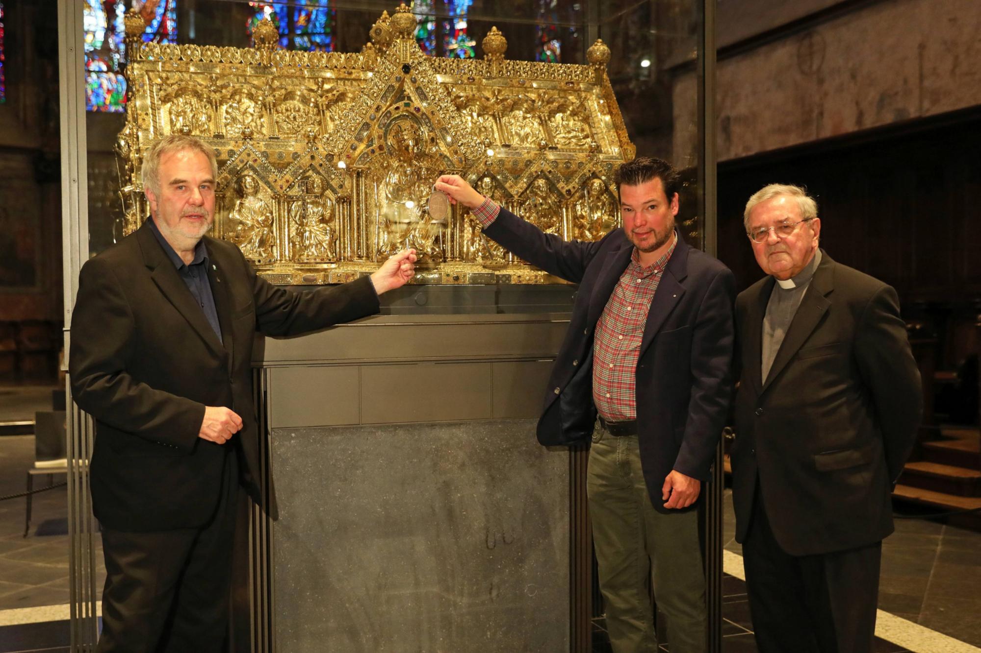 Dompropst Rolf-Peter Cremer (v.l.), Goldschmied Thomas Zintzen und Stifter Bischof em. Dr. Heinrich Mussinghoff vor Marienschrein im Aachener Dom.