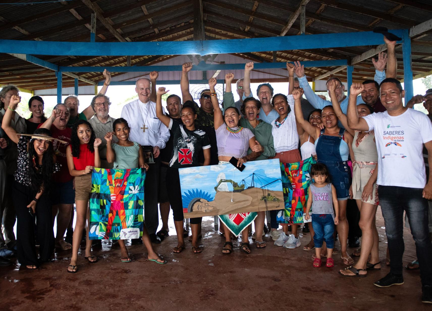 Deutscher Besuch im Erzbistum Manaus. Neben einem Poster zum Raubbau der Natur in Amazonien (rechts) ist das Gemälde des Kolumbianers Freddy Sánchez Caballero zu sehen, das Adveniat Papst Franziskus 2019 zur Amazoniensynode in Rom überreichte. (c) Florian Kopp/Adveniat