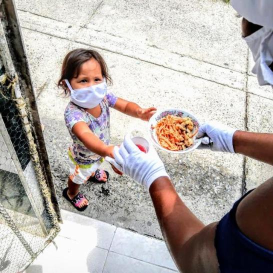 Ein Mädchen erhält eine Lebensmittelspende (c) Sozialpastoral im Erzbistum Cali