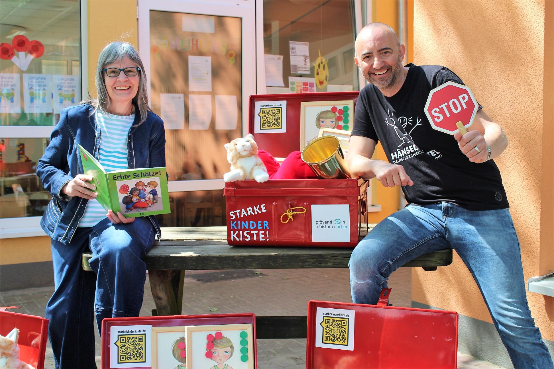 Almuth Grüner, Präventionsbeauftragte beim Bistum Aachen und Jerome Braun, Geschäftsführer der Kinderschutzstiftung Hänsel + Gretel, freuen sich, dass die 'Starke Kinder Kiste!' jetzt in den Kitas des Bistums Aachen eingesetzt wird.