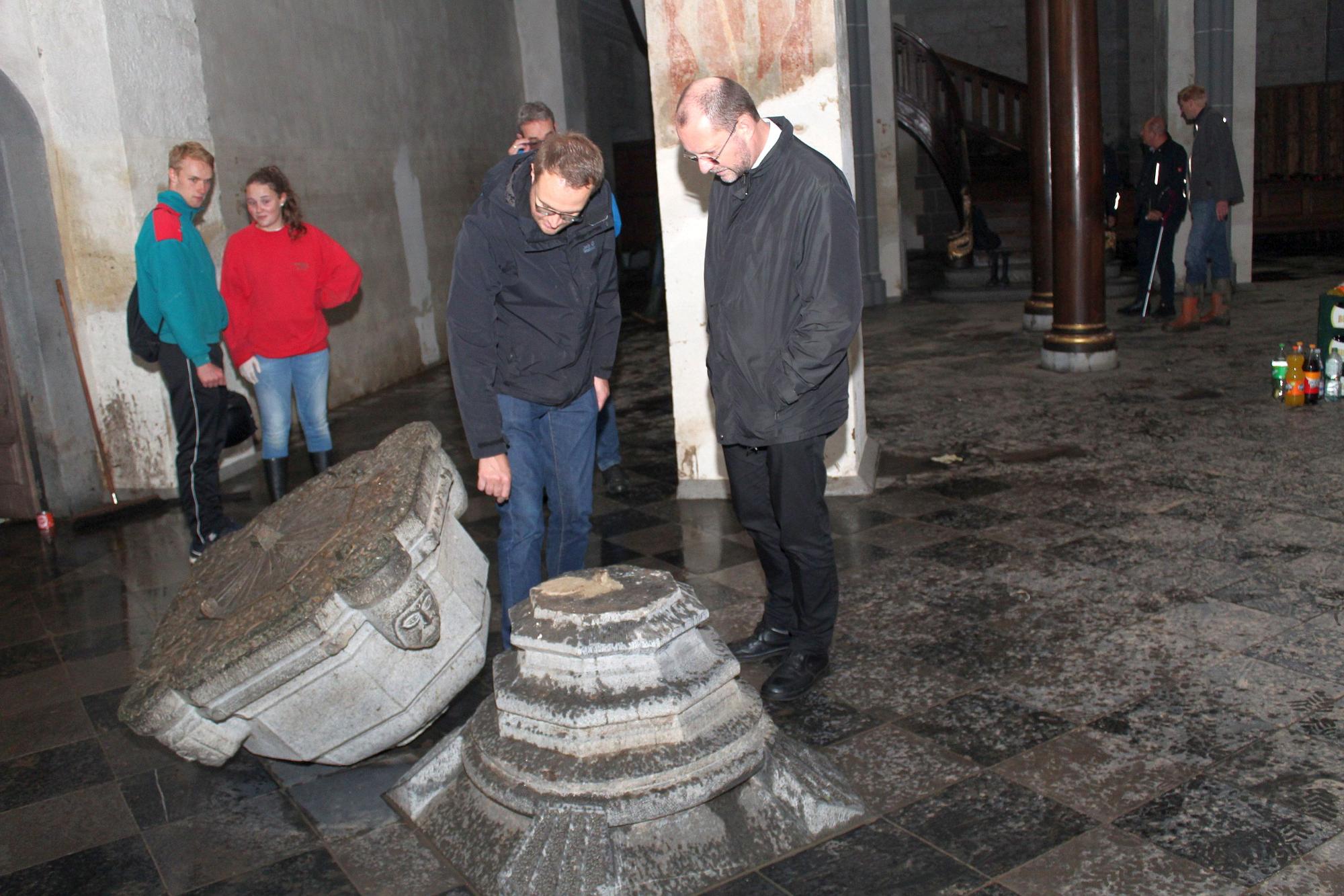 Generalvikar Dr. Andreas Frick (rechts) begutachtet gemeinsam mit Pfarrer Dr. Andreas Möhlig (links) die Hochwasserschäden in der Propsteikirche St. Kornelius in Kornelimünster.