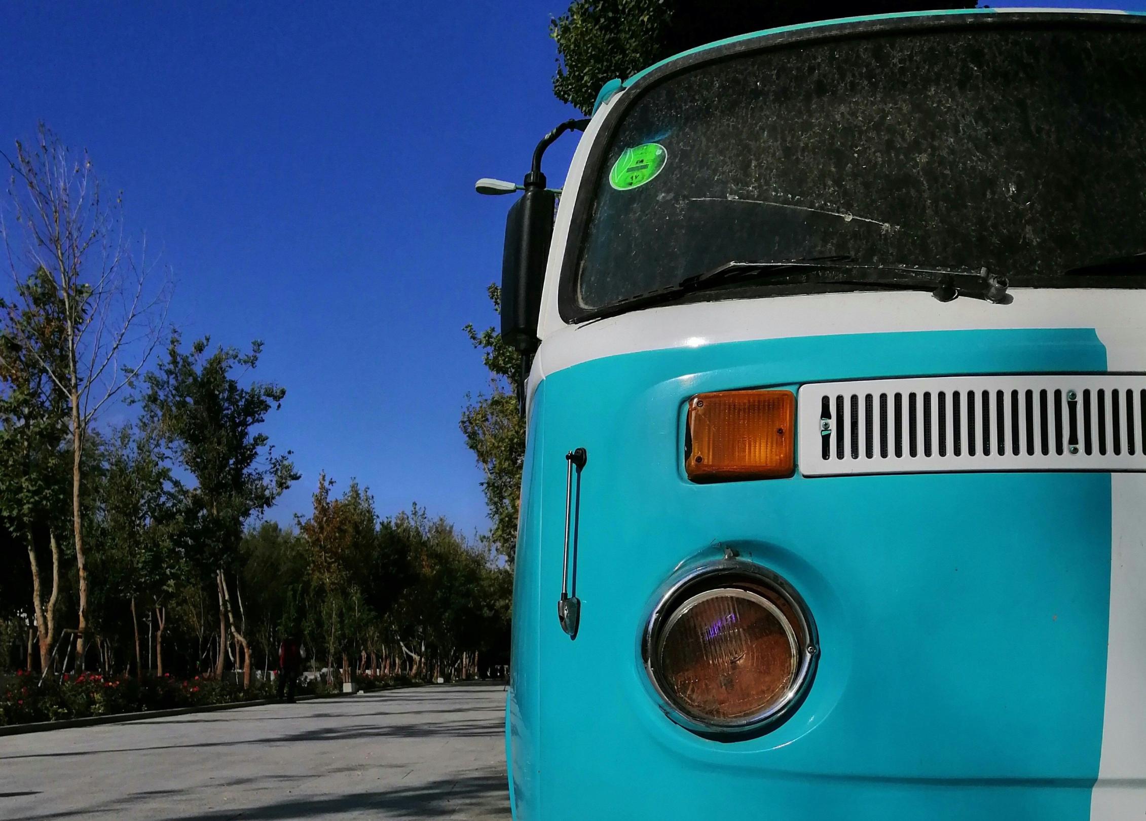 alter Bulli in hellblau vor strahlend blauem Himmel