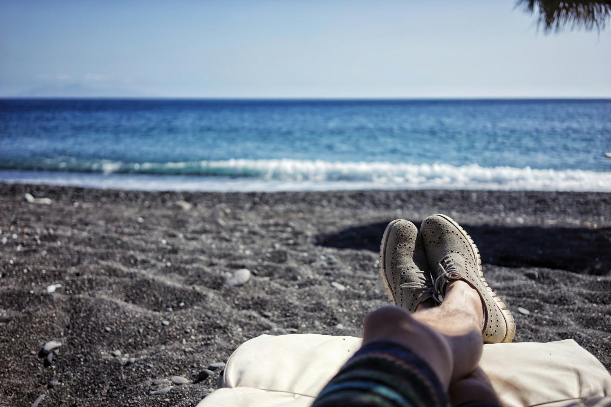 Beine eines Manns am Strand