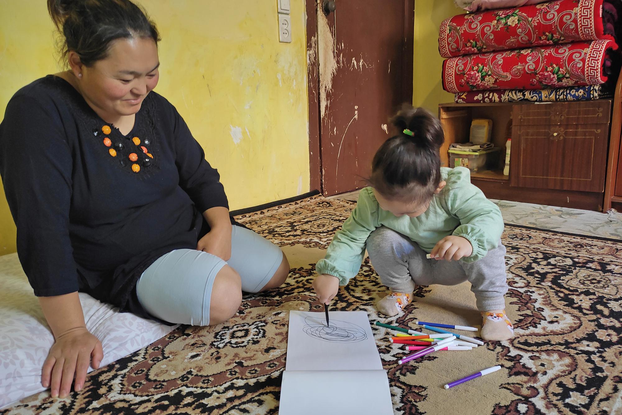 Perizad und ihre Tochter Aziza. Außer den Teppichen, auf denen sie schlafen und sitzen, besitzt die dreiköpfige Familie kein einziges Möbelstück.