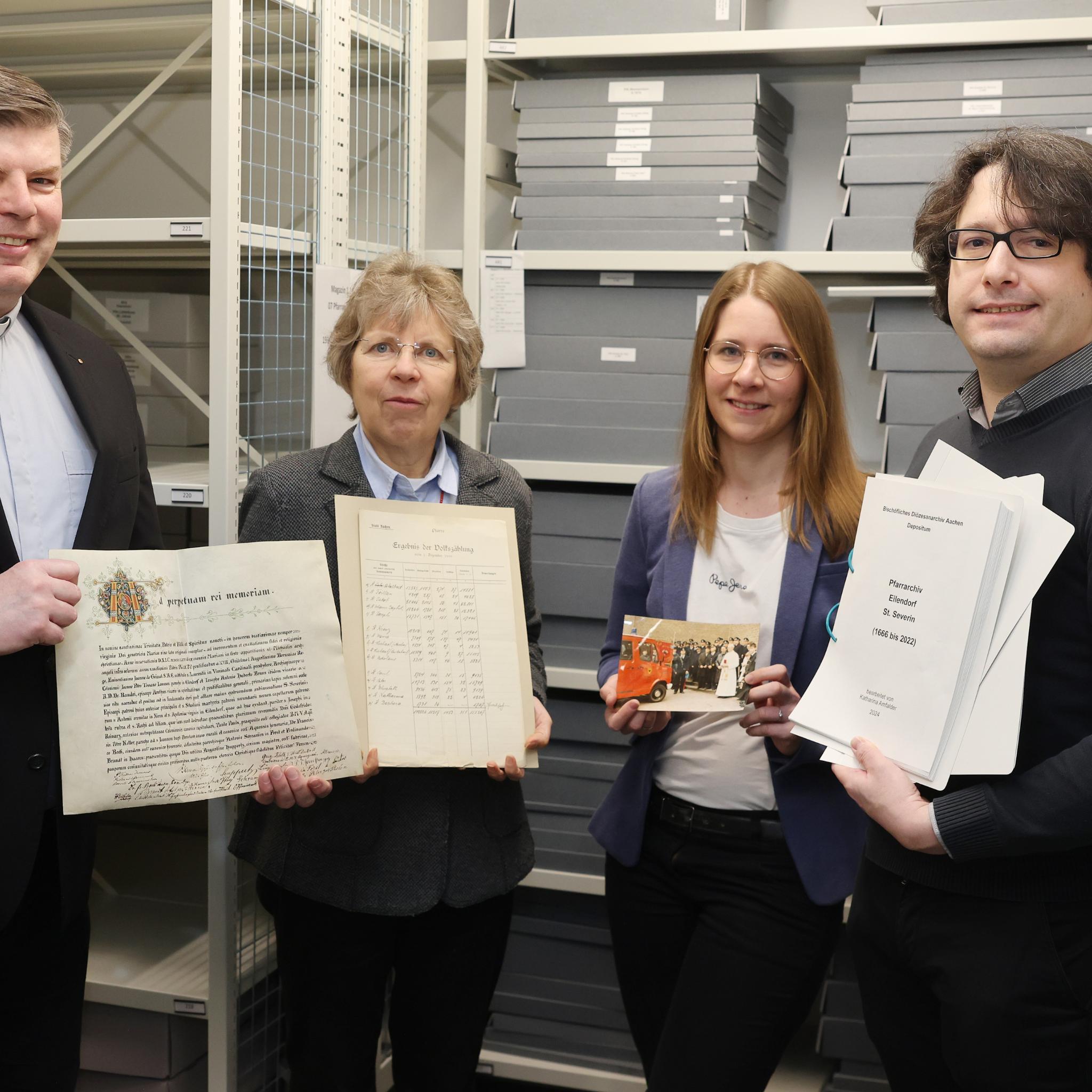 Angekommen im „Gedächtnis des Bistums Aachen“: Über die sichere Lagerung der Pfarrarchive und die Übergabe der Findbücher freuen sich (von links) der Eilendorfer Pfarrer Alexius Puls, Diözesanarchivdirektorin Dr. Beate Sophie Fleck, Referentin für Pfarrarchivpflege Katharina Amfalder sowie Juliano de Assis Mendonça, Archivberater beim Landschaftsverband Rheinland (LVR)