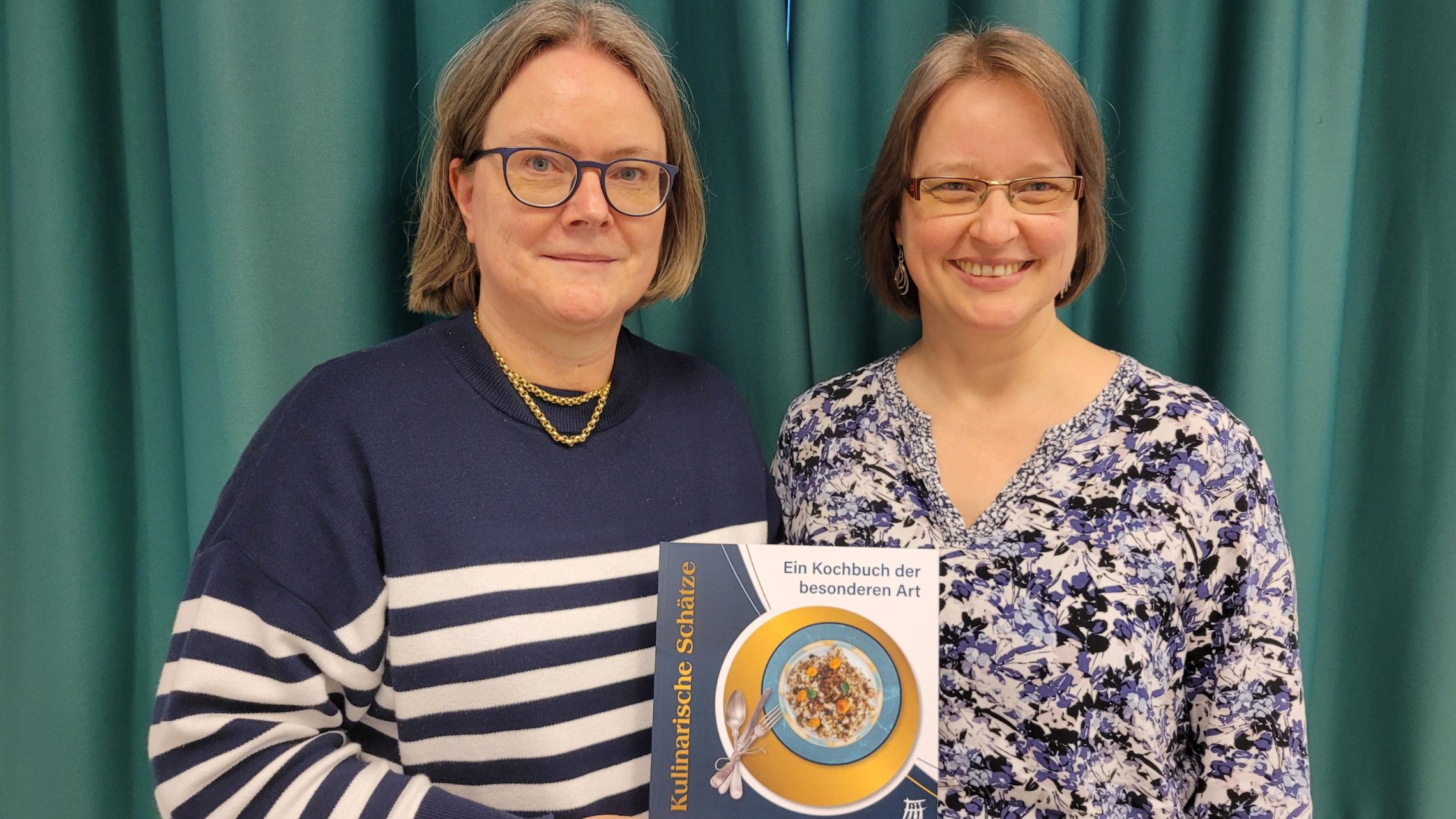 Anne Embser, Vorsitzende des Familienbundes, und Diana Emmelheinz, Geschäftsführende des Familienbundes, mit dem Kochbuch