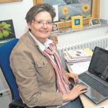 Blumen und farbenfrohe Bilder kennzeichnen die Arbeitsumgebung von Ingrid Scholz.