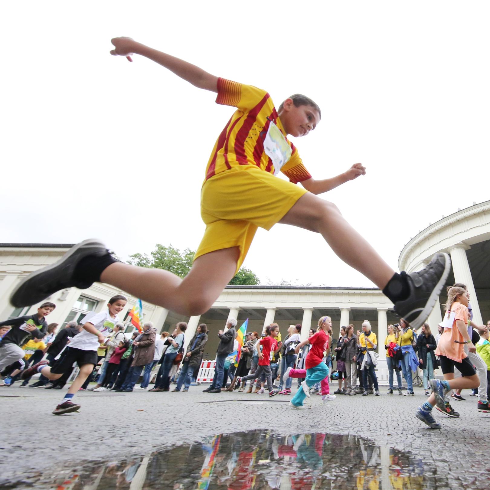 Aachener Friedenslauf, Junge springt über eine Pfütze