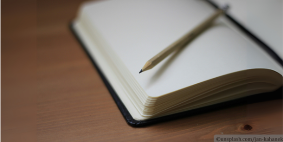 aufgeschlagenes Buch mit einem Stift darin