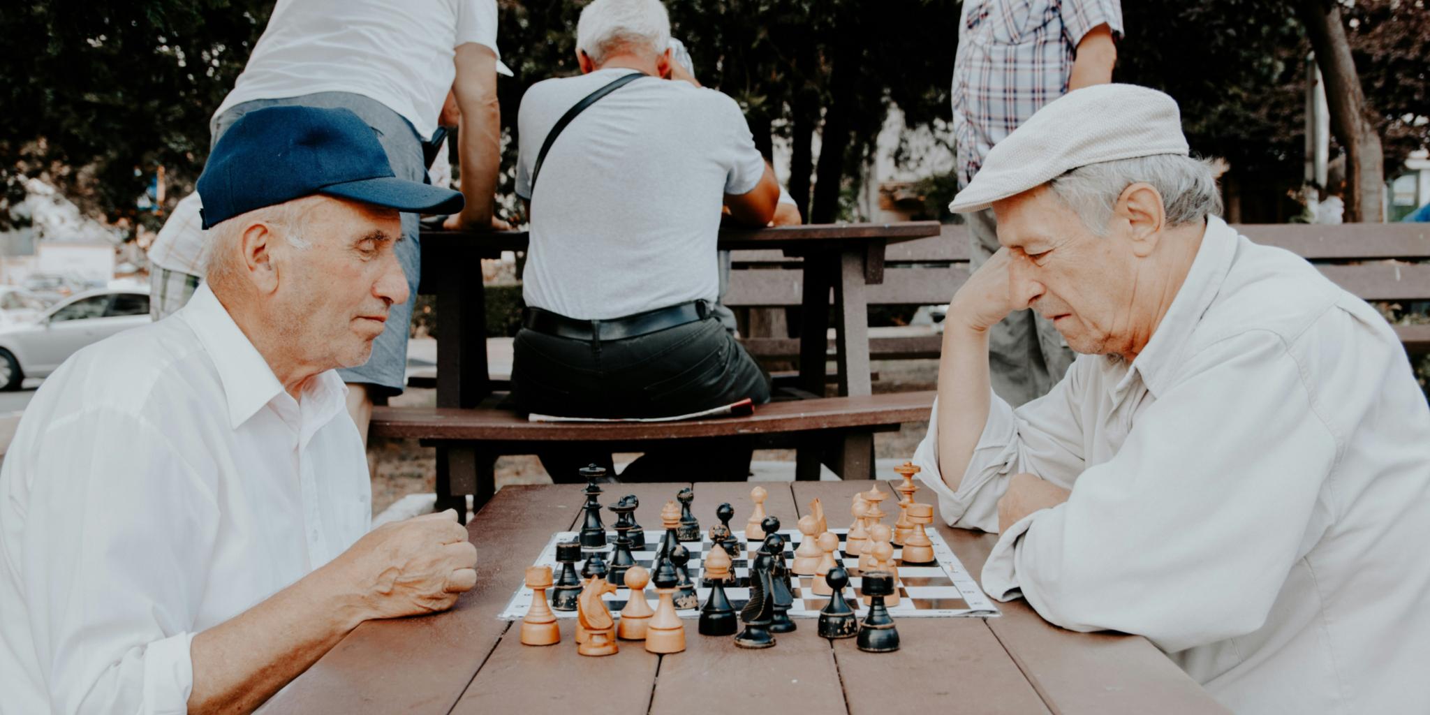 Zwei hochaltrige Männder spielen Schach zusammen