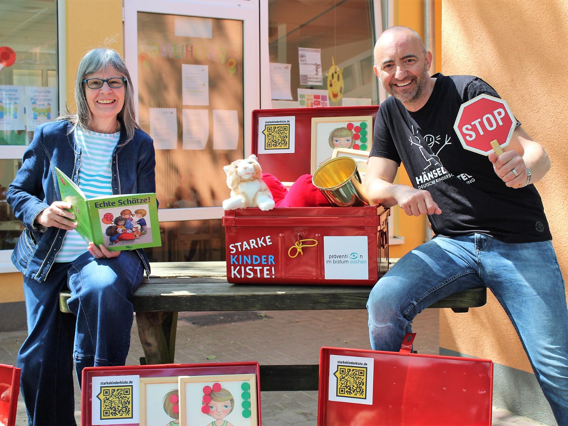 Almuth Grüner, Präventionsbeauftragte beim Bistum Aachen und Jerome Braun, Geschäftsführer der Kinderschutzstiftung Hänsel + Gretel, freuen sich, dass die 'Starke Kinder Kiste!' jetzt in den Kitas des Bistums Aachen eingesetzt wird.