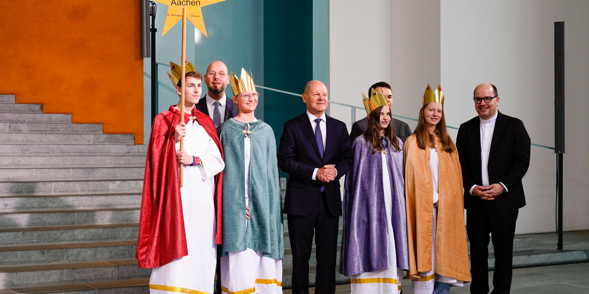 Zum Gruppenfoto mit dem Kanzler stellten  sich die Sternsinger aus Viersen gemeinsam mit Pfarrer Dirk Bingener, Präsident des Kindermissionswerks ‚Die Sternsinger‘, und Domvikar Stefan Ottersbach, Bundespräses des Bundes der Deutschen Katholischen Jugend (BDKJ), im Bundeskanzleramt auf.