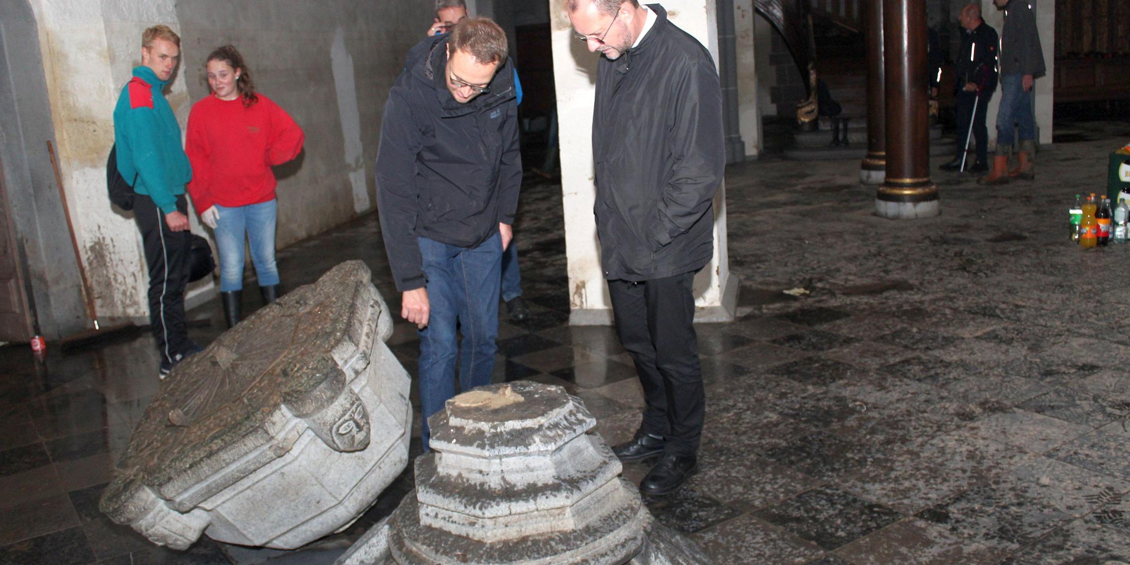 Generalvikar Dr. Andreas Frick (rechts) begutachtet gemeinsam mit Pfarrer Dr. Andreas Möhlig (links) die Hochwasserschäden in der Propsteikirche St. Kornelius in Kornelimünster.