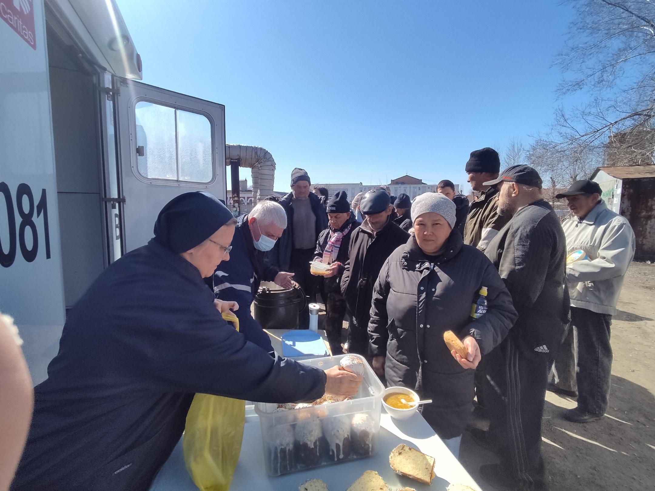 Eine Besucherin des Ambulanzbusses 'Vinzenz' erhält ihr Mittagessen.