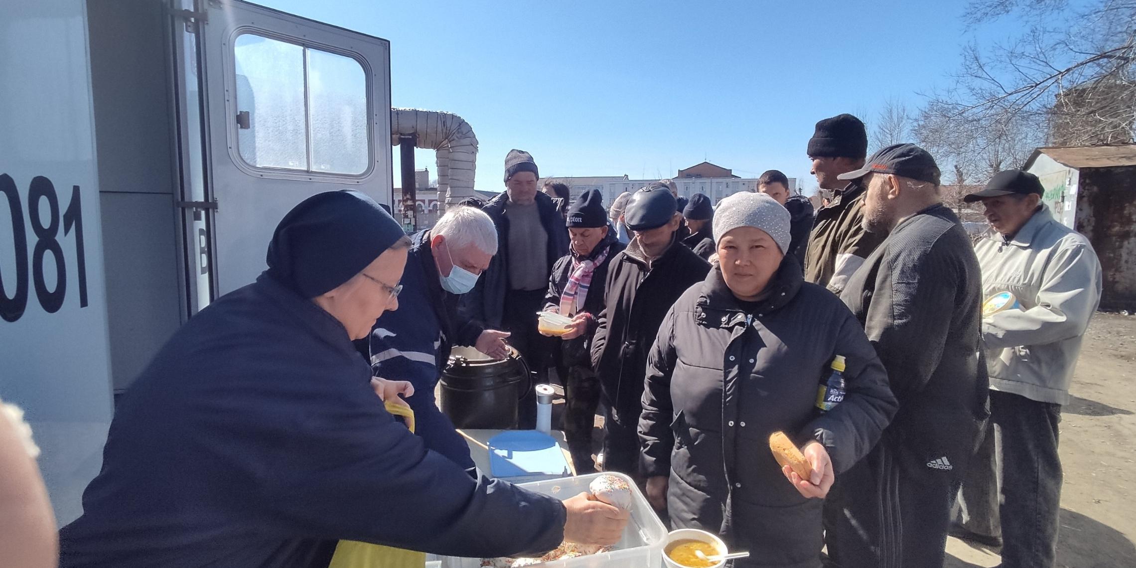 Eine Besucherin des Ambulanzbusses 'Vinzenz' erhält ihr Mittagessen.