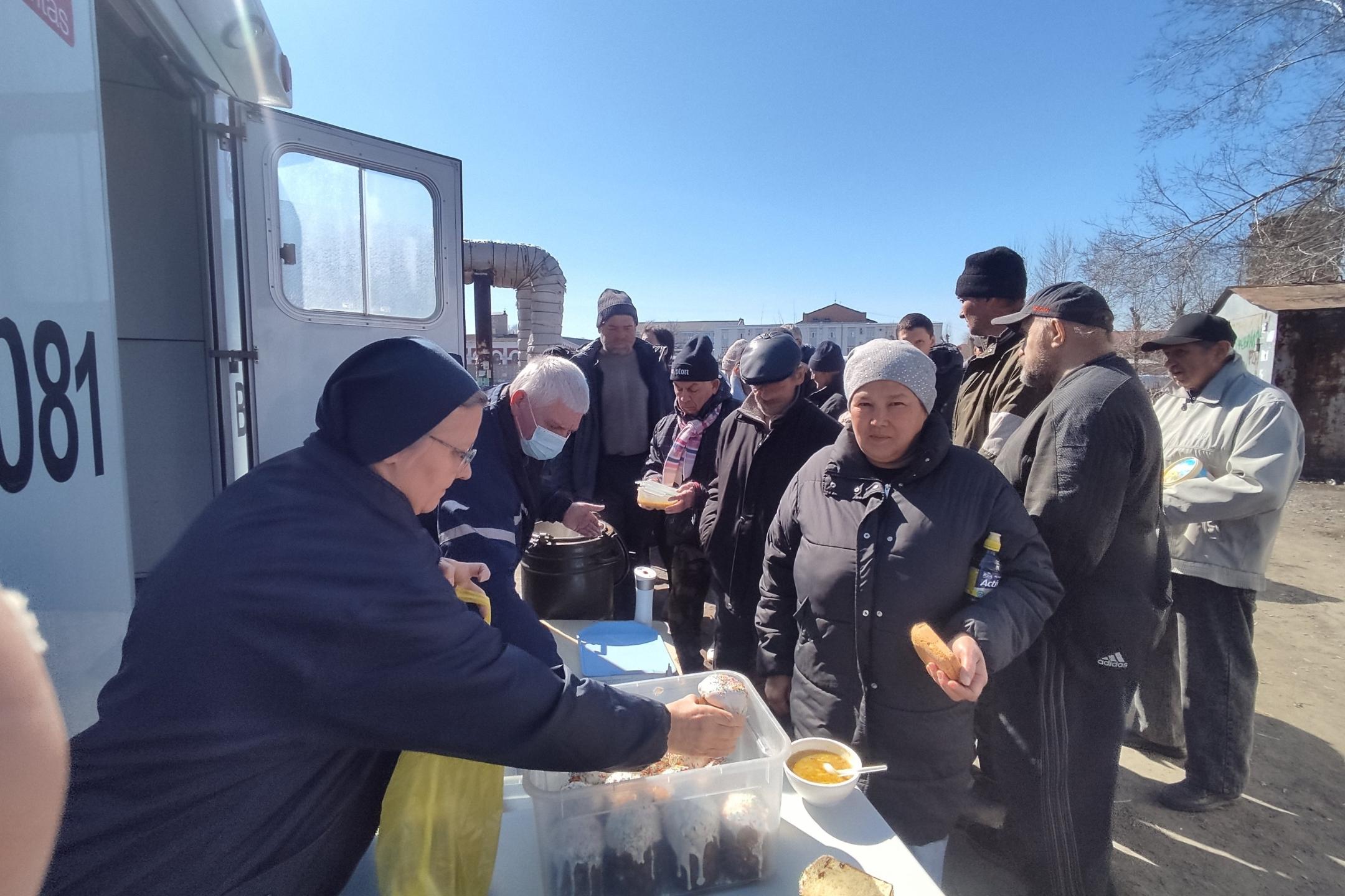 Eine Besucherin des Ambulanzbusses 'Vinzenz' erhält ihr Mittagessen.