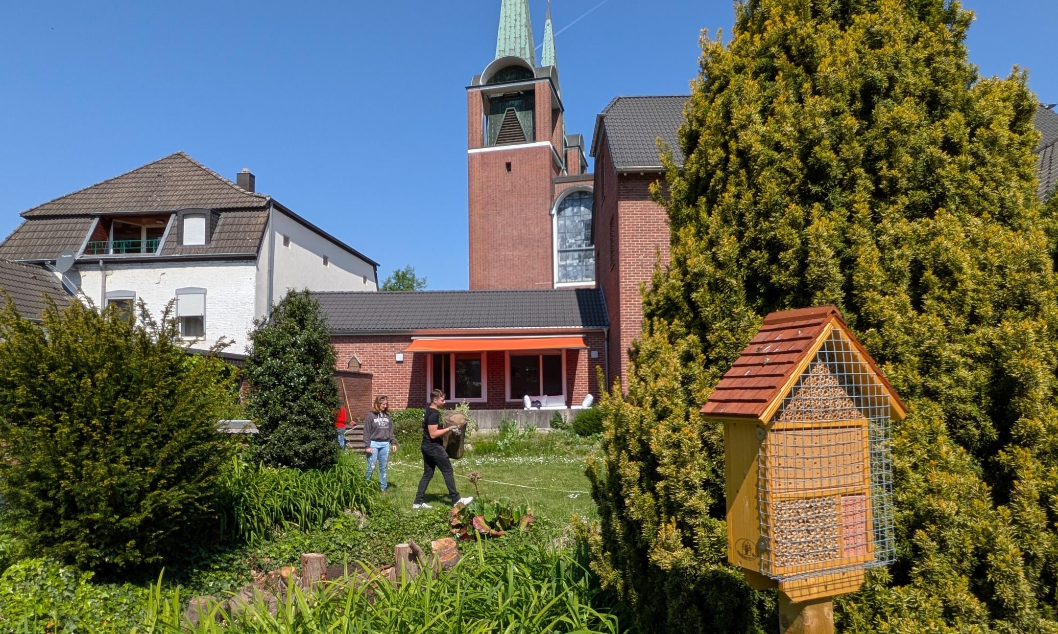 Das Bild zeigt einen Garten mit viel Wiese und einem Vogelhaus. Im Hintergrund sind ein Haus und eine Kirche (c) Bistum Aachen / Steffi Sieger-Bücken Das Bild zeigt einen Garten mit viel Wiese und einem Vogelhaus. Im Hintergrund sind ein Haus und eine Kirche