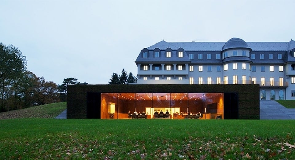 Außenansicht des Parlamentsgebäudes, ein ehemaliges Sanatorium aus dem Jahr 1915 mit einem vorgebauten Plenarsaal mit Glasfront.