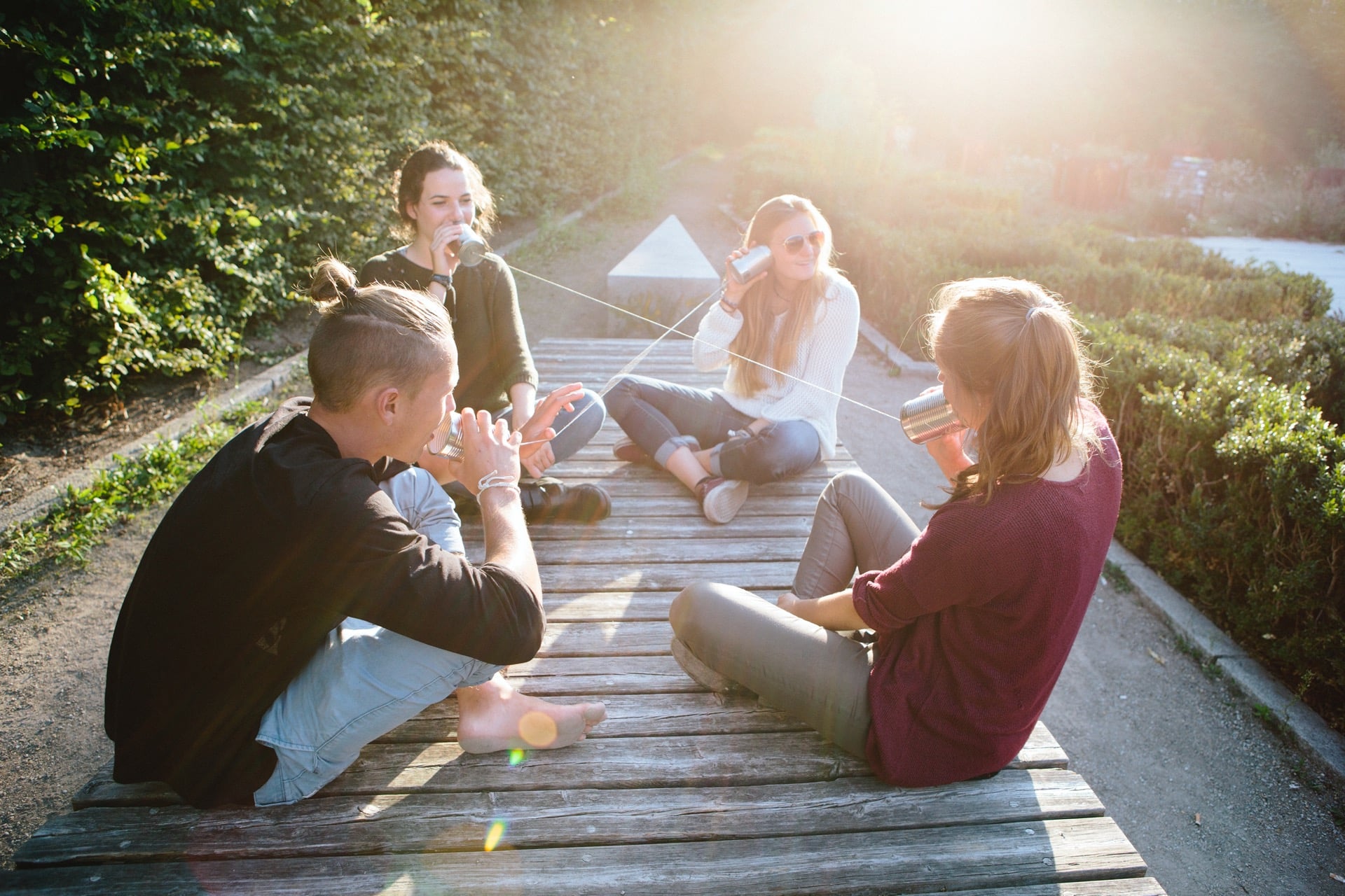 Junge Menschen sitzen in einer Gruppe auf dem Boden und unterhalten sich.
