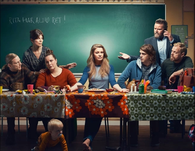 Filmplakat der dänischen Serie 'Rita', die Hauptperson in der Mitte, die Personen wie bei da Vincis Abendmahlsbild angeordnet.