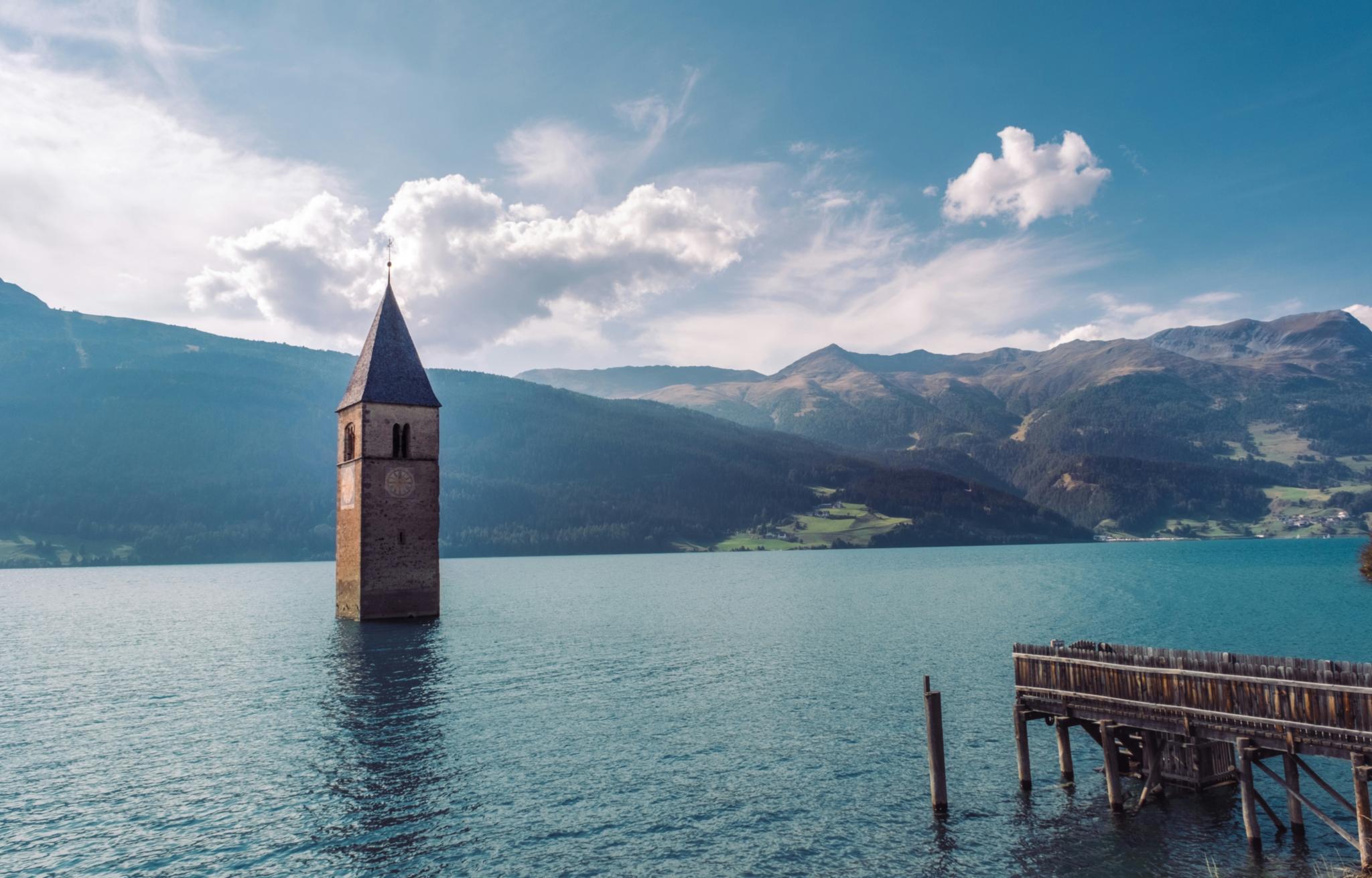 Kirchturm ragt aus der Wasseroberfläche, das Gebäude scheint darunter zu liegen