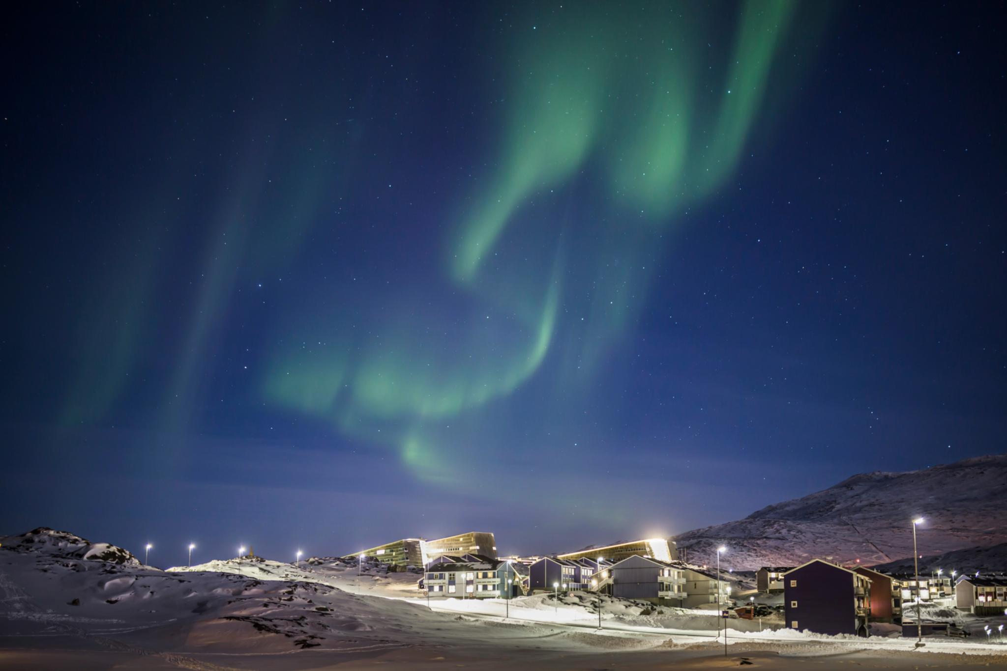 Polarlicht über Häusern auf Grönland