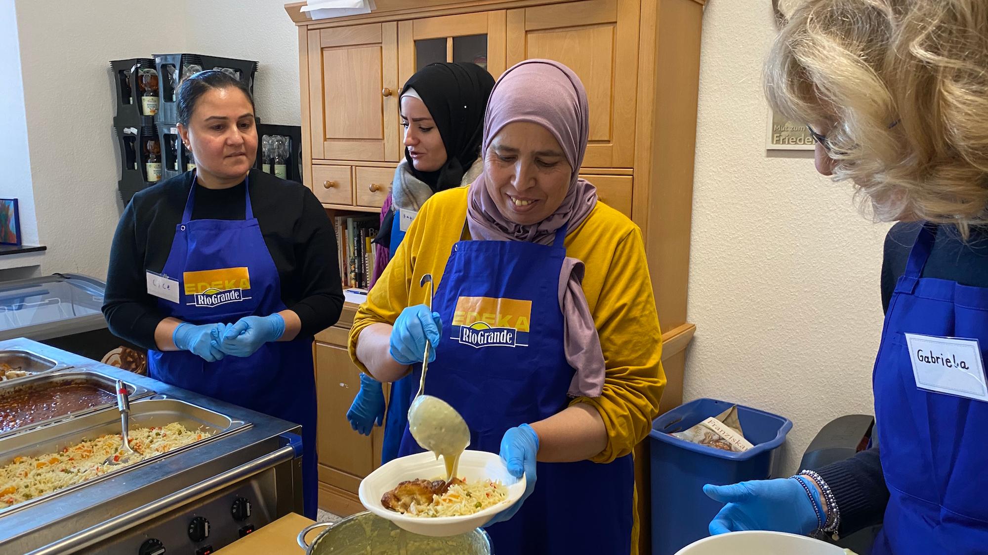 Cice, Fatima, Khadija und Gabriela (v. l.) arbeiten an der Essensausgabe Hand in Hand. Nur gemeinsam klappt es.