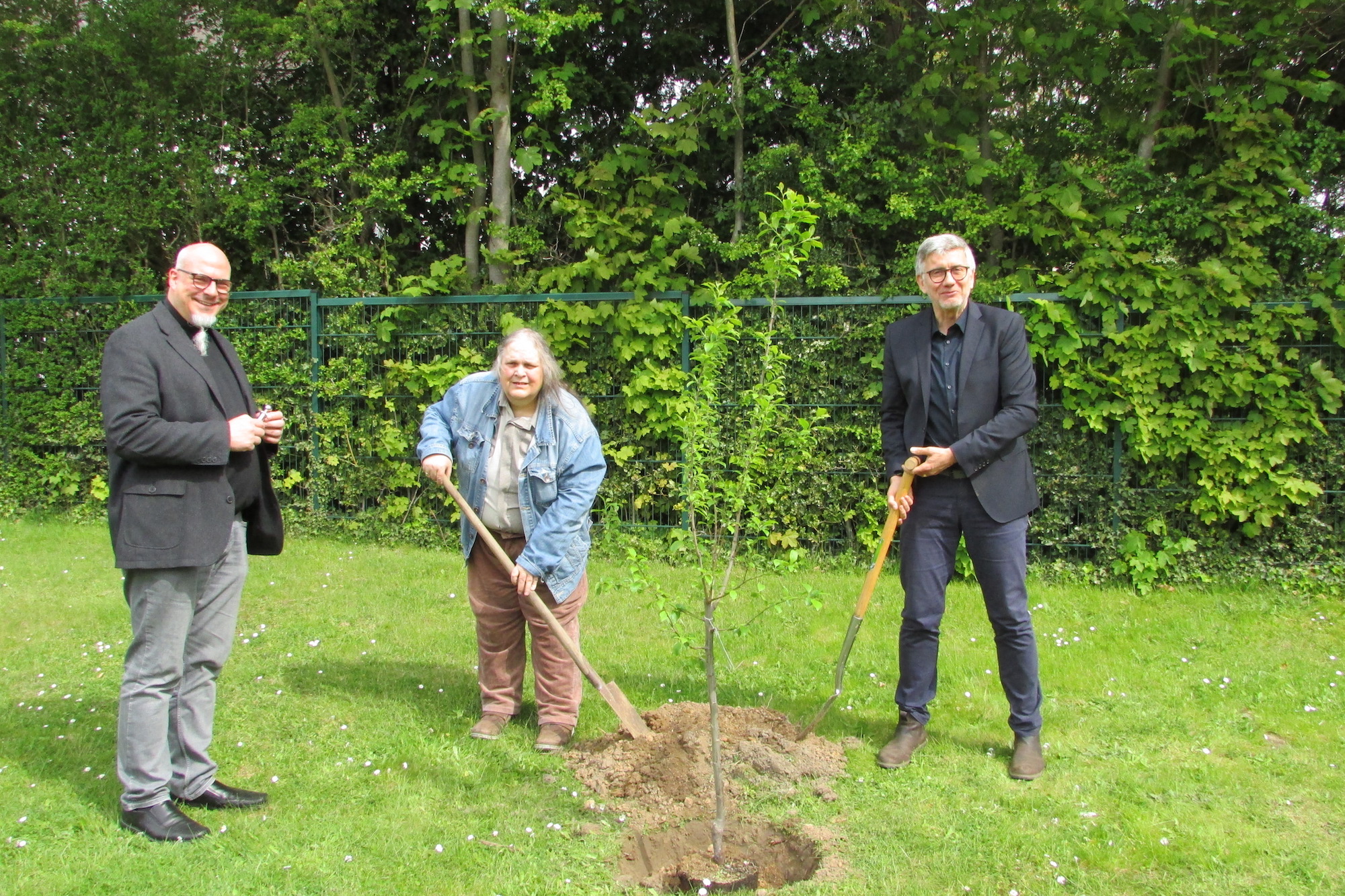 Mit Pfarrer Michael Datené (l.) und dem Geschäftsführer des Hauses St. Josef, Robert Wagner, pflanzt Hermine Schneider den Pflaumenbaum.