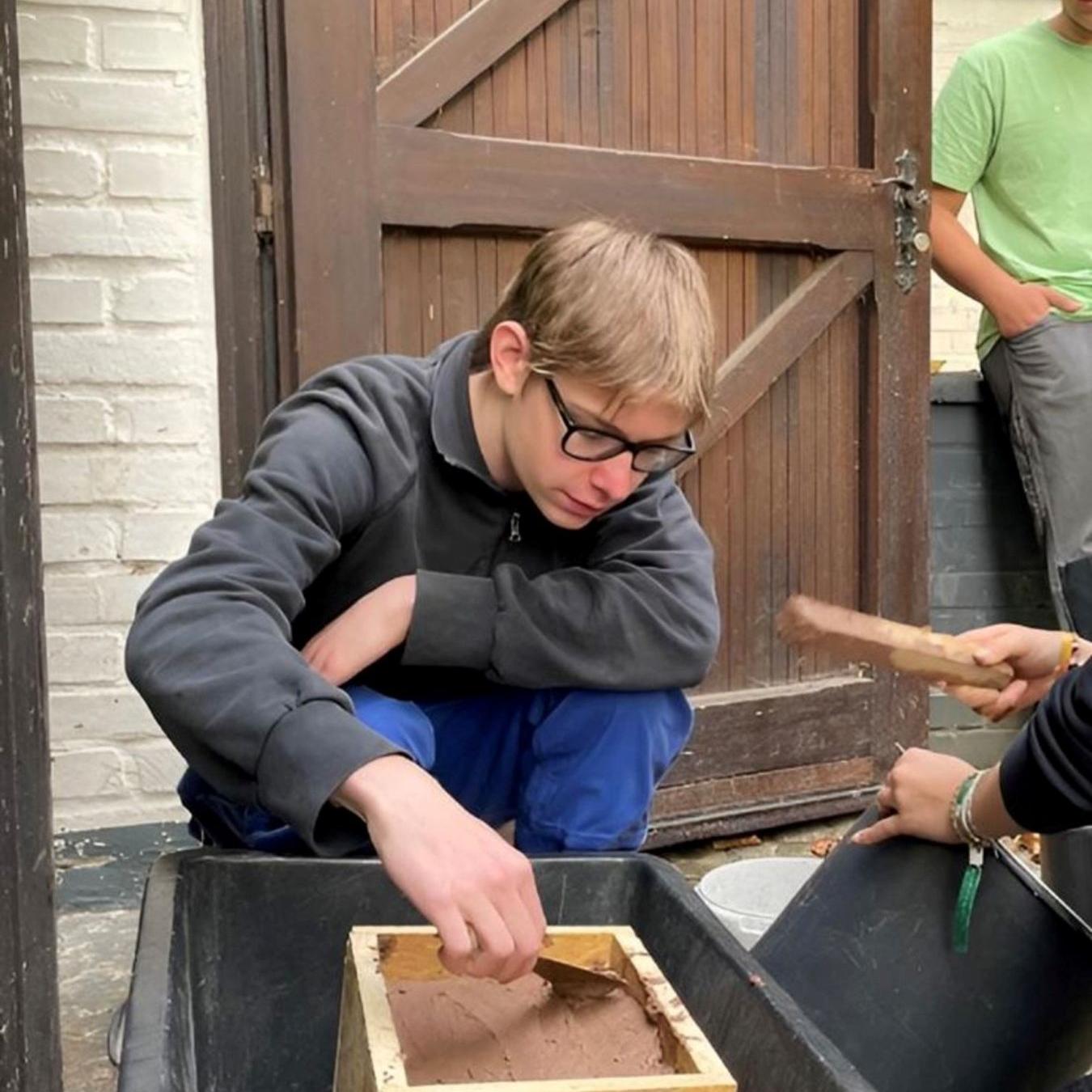 Lars Decker erwirbt als Bufdi praktische und soziale Kompetenzen. Hier fertigt er einen Lehmziegel für ein Insektenhotel an.