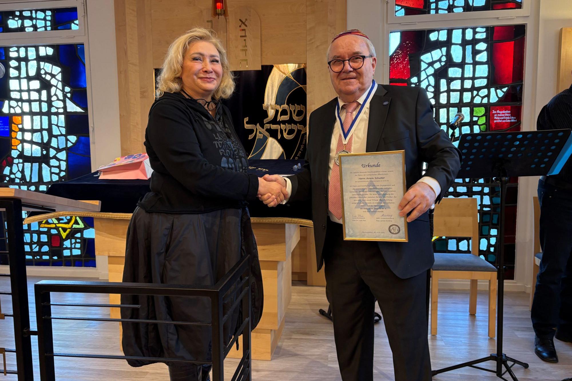 Leah Floh, Vorsitzende der jüdischen Gemeinde, zeichnet Armin Schuster, Vorsitzender der GCJZ, mit der Hans-Jonas-Medaille aus.