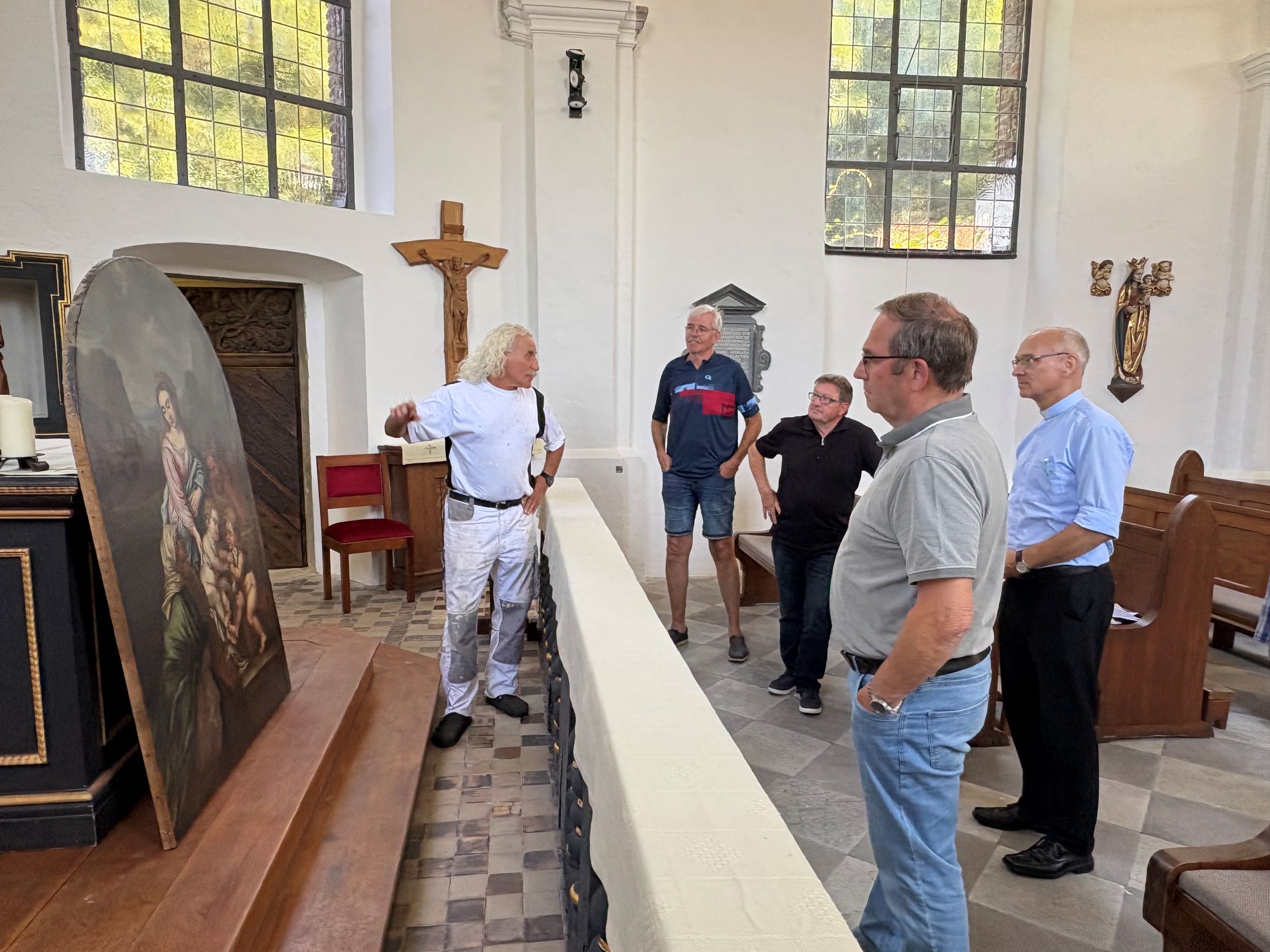 Kirchenmaler Norbert Seidel erklärt Karl-Heinz Roehlen, Josef Schnock, Wolfgang Esser und Marc Zimmermann die Arbeiten an dem Altarbild.