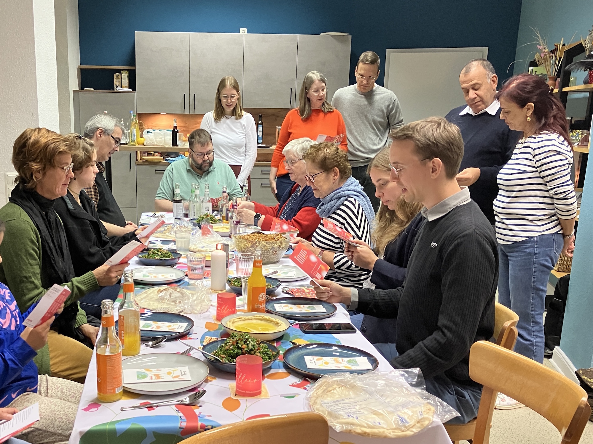 Bei Humus, Tabouleh und Linsen mit Zwiebeln und Reis versammeln sich Gäste, Gemeindemitglieder und Missio-Mitarbeiter um einen Tisch.