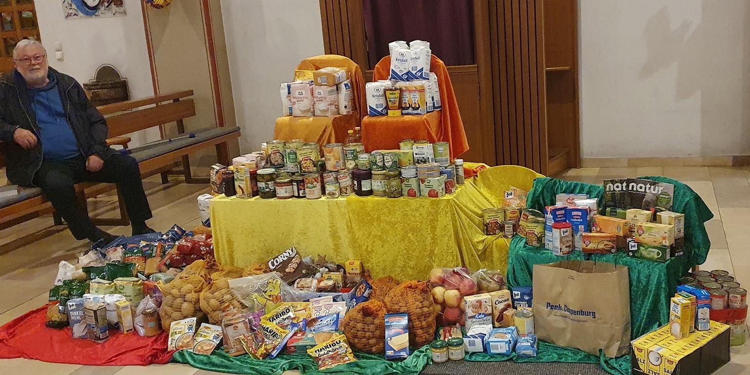 Kirchenaktivist Werner Zeyen neben einem Berg haltbarer Lebensmittel, der bei einem der früheren Sankt-Martins-Gottesdienste für die Mechernicher Tafel zusammenkam.