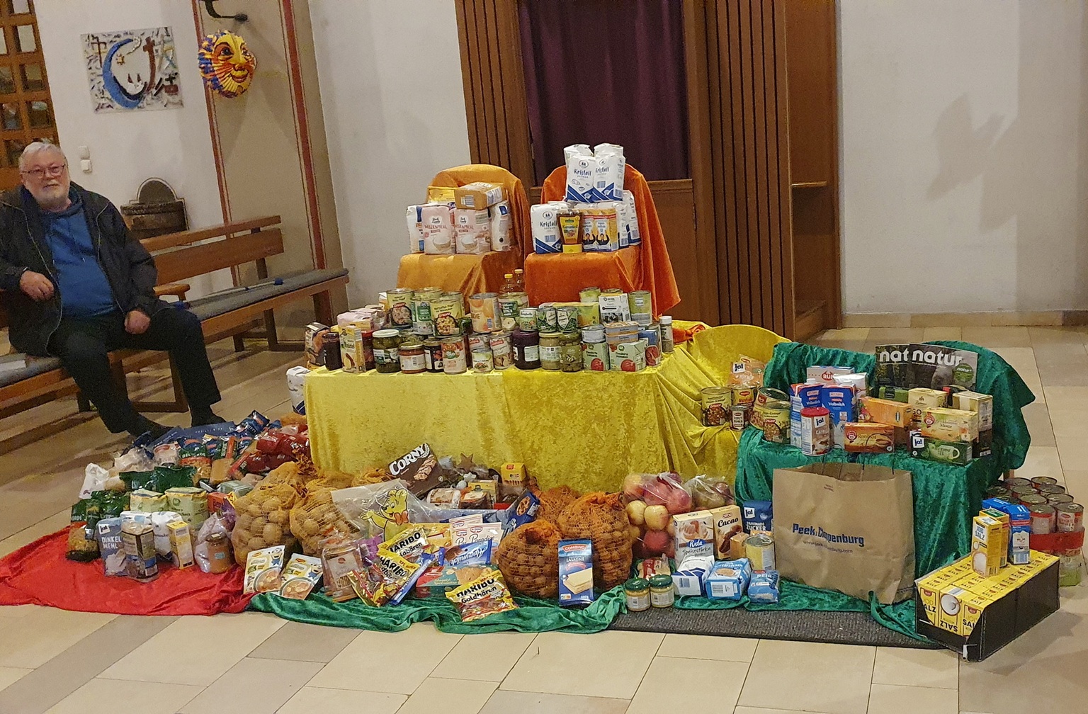 Kirchenaktivist Werner Zeyen neben einem Berg haltbarer Lebensmittel, der bei einem der früheren Sankt-Martins-Gottesdienste für die Mechernicher Tafel zusammenkam.