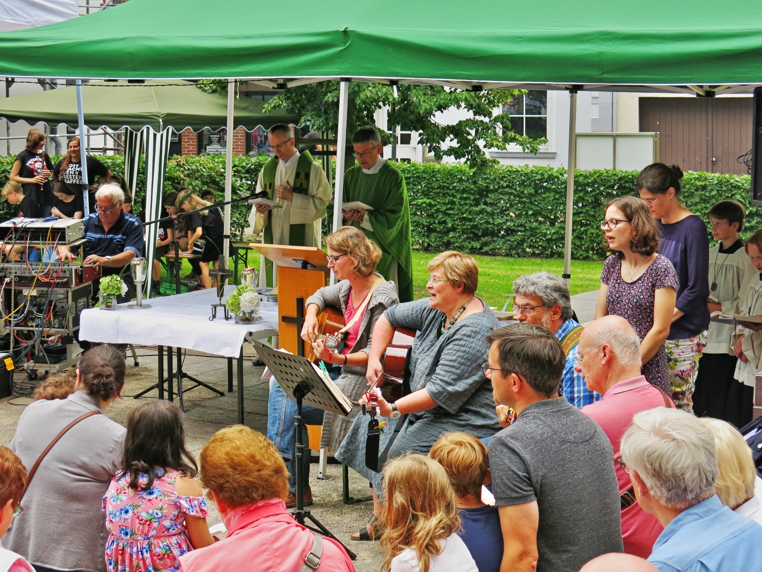 Pfarr- und Heimatfest 2018:   Pfarrer Viertel und Pater Simo zelebrieren die Festmesse auf dem Kirchvorplatz von St. Stephanus  (Wegen plötzlich auftretenden Regens musste die Messe nach den Fürbitten in die Kirche verlegt werden.)
