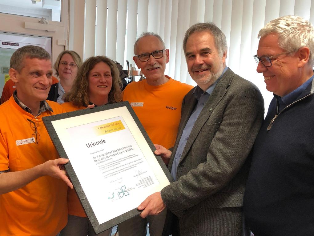 Pfr. Rolf-Peter Cremer (2.v.r.), Leiter der Hauptabteilung Pastorl / Schule / Bildung, und Dieter Spoo (r), Diözesanrat der Katholiken, übergaben die Urkunde an die Ehrenamtlichen des Repair Cafés.
